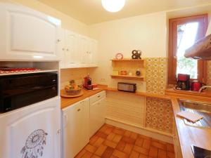 a kitchen with white cabinets and a stove top oven at Domaine de Bellevue Gîte du Mont Begon in Marnoz +19 photos