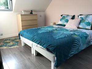 Schlafzimmer mit einem Bett mit blauer Decke in der Unterkunft Studio T1BIS BORD DE PLAGE in Saint-Lunaire