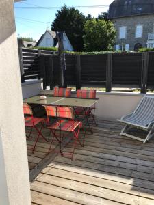Un patio con una mesa y sillas en una terraza. en Studio T1BIS BORD DE PLAGE, en Saint-Lunaire