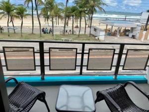 een uitzicht op het strand vanuit een bus met stoelen bij Santa Helena Pousada in Guarujá