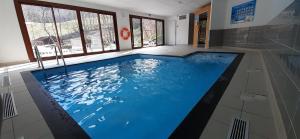 una grande piscina in una stanza con finestre di Appartement résidence des Bottières a Saint-Pancrace