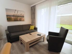 ein Wohnzimmer mit einem Sofa und einem Couchtisch in der Unterkunft Apartmenthaus Jasmin in Büsum