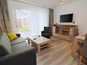 sala de estar con sofá y mesa en Apartmenthaus Jasmin, en Büsum