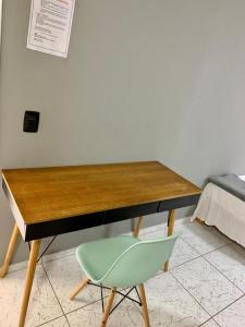 グアルジャにあるSanta Helena Pousadaのベッドの横に緑の椅子とデスク