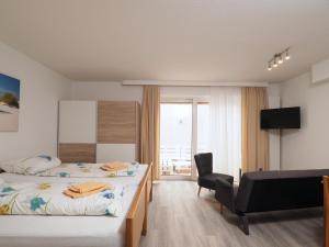 a hotel room with two beds and a chair at Apartmenthaus Jasmin in Büsum