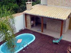 a swimming pool with a gazebo on a patio at Apartamento Costa Esmeralda in Bombinhas