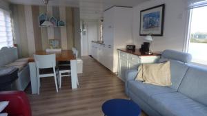sala de estar con sofá y cocina con mesa en Chalet Seazon O1 en Buren