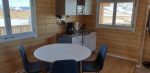 a kitchen with a white table and chairs in a cabin at Hvammur 4 with private hot tub (Fagurgali) in Drangsnes
