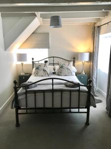 a bedroom with a bed with two lamps and a window at The Cottage in Pembrokeshire
