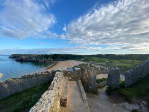 an old stone wall next to a beach at The Cottage in Pembrokeshire