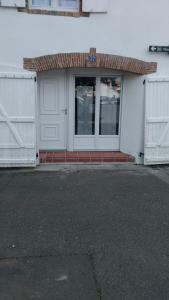 un garaje blanco con dos puertas y una ventana en Au cœur de Pornic en Pornic