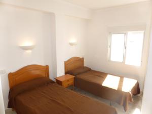 a bedroom with two beds and a window at Ático a 100 metros de la playa in Cullera