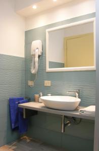 bagno con lavandino bianco e specchio di I Borghi a Empoli