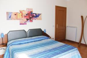 1 dormitorio con 1 cama y una pintura en la pared en I Borghi, en Empoli