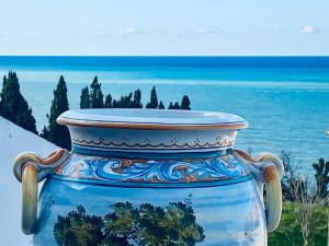 a blue and white vase sitting next to the ocean at CasAzzurra in Ortona