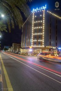 una calle de la ciudad con un edificio por la noche con luces en أرائك توق, en Sakaka