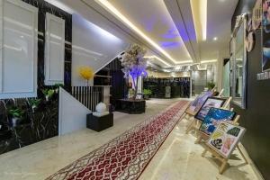 a lobby with a staircase with chairs and flowers at أرائك توق in Sakakah