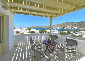 a patio with a table and chairs on a balcony at Diasino Apartments and Car Rental in Katapola