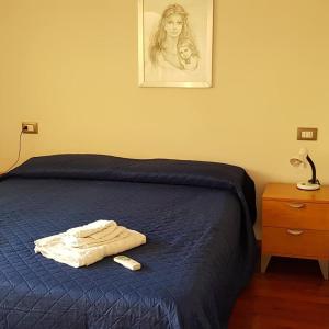 un letto con una coperta blu e un telecomando sopra di Petra Marina Maris a Pisciotta