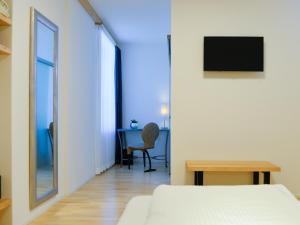 a bedroom with a bed and a desk and a mirror at Hotel Baders Krone in Laupersdorf