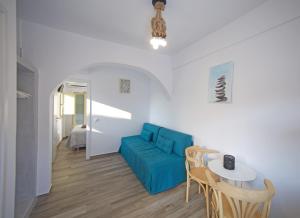 a living room with a blue couch and a table at Diasino Apartments and Car Rental in Katapola