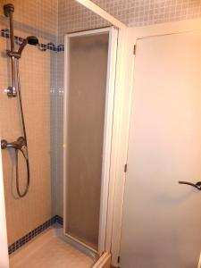 a shower with a glass door in a bathroom at Ático a 100 metros de la playa in Cullera