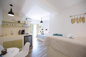 a bedroom with two beds and a table and chairs at Diasino Apartments and Car Rental in Katapola