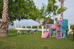 a playground in a park with chairs and a tree at Neptune Resort in Kavos