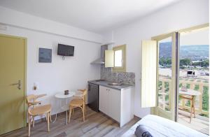 a room with a kitchen and a table with chairs at Diasino Apartments and Car Rental in Katapola