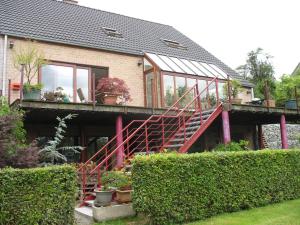 une maison avec un escalier rouge devant elle dans l'établissement Gesves Côté Jardin, à Gesves