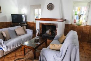 ein Wohnzimmer mit zwei Sofas und einem Kamin in der Unterkunft Casa Rural San Antonio in Cabra