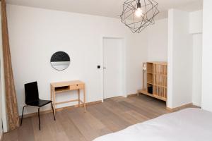 1 dormitorio con cama, escritorio y silla en Boonuz guesthouse, luxe duplex vakantiehuis in centrum Ieper met privé lounge terras en IR sauna, en Ypres
