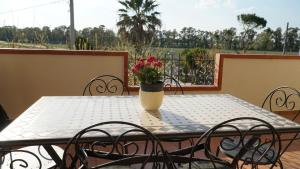 a table with a vase of flowers on a balcony at Home sweet Home in Metaponto