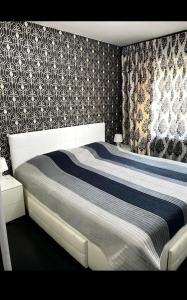 a bedroom with a large bed with black and white wallpaper at Apartament Nicolas in Brezoi