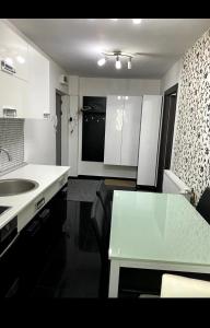 a kitchen with a sink and a table in it at Apartament Nicolas in Brezoi