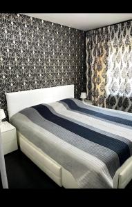 een slaapkamer met een bed met een blauwe en witte deken bij Apartament Nicolas in Brezoi