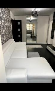 een woonkamer met een witte bank en een spiegel bij Apartament Nicolas in Brezoi