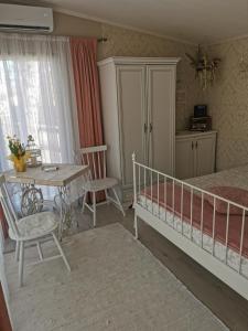 a bedroom with a bed and a table and a table and chairs at Holiday Home Kolka in Kolka