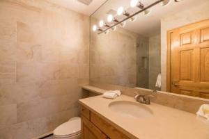 a bathroom with a sink and a toilet and a mirror at Strawberry Park Ski In Ski Out Condo in Beaver Creek