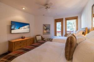 a bedroom with two beds and a tv on the wall at Strawberry Park Ski In Ski Out Condo in Beaver Creek +16 photos