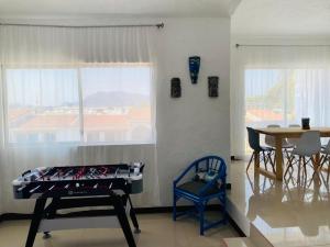 a room with a bed and a table and a window at Cocotero Manzanillo in Manzanillo