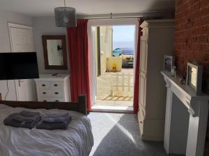 a bedroom with a bed and a door to a yard at Sea view studio in Felixstowe