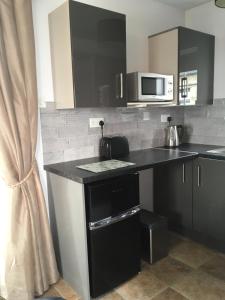 a kitchen with a black counter and a microwave at Binnian Gateway in Ballymartin +17 photos