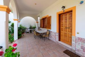 patio con mesa, sillas y puerta de madera en Villa Sophia Apartments by CorfuEscapes, en Agios Gordios