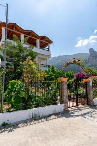 una cerca negra con flores delante de una casa en Villa Sophia Apartments by CorfuEscapes, en Agios Gordios