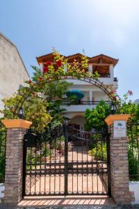 a house with a gate with flowers on it at Villa Sophia Apartments by CorfuEscapes in Agios Gordios
