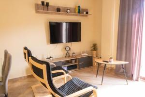 a living room with a table and a tv on the wall at Apartamento Turístico Snow Boutique in Camarena de la Sierra
