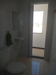baño con aseo y lavabo y ventana en Pousada Obedemar - Taipu de fora, Barra Grande, Ba, en Barra Grande