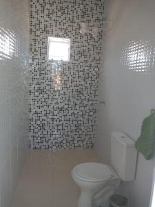 uma casa de banho com um WC branco e um chuveiro em Pousada Obedemar - Taipu de fora, Barra Grande, Ba em Barra Grande