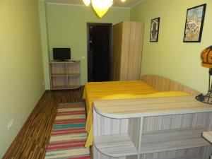 1 dormitorio con cama amarilla y TV en Vila Europa, en Sărata-Monteoru